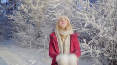 Bir kadın, güzel, soğuk bir sabahta karla kaplı ağaçlarla kış ormanlarında yürür. Yavaş Hareket