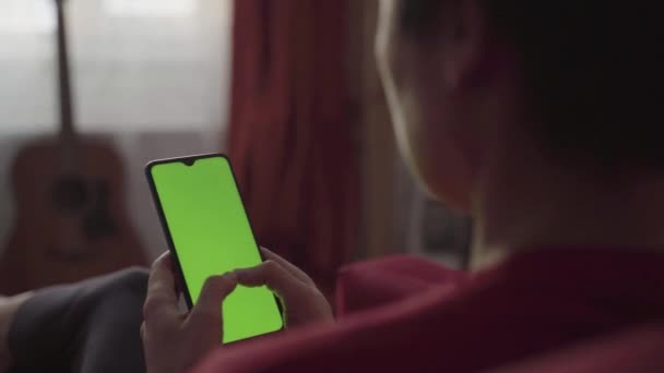 Bakåt syn på Kvinna håller Chroma Key Green Screen Smartphone — Stockvideo