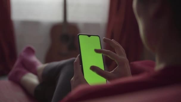 Bakåt syn på Kvinna håller Chroma Key Green Screen Smartphone — Stockvideo