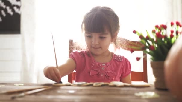 Mała dziewczynka maluje ciasteczka halloween — Wideo stockowe