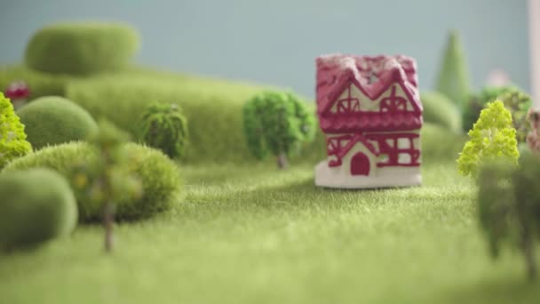 Skylt hus Uthyres i ett område med grönt gräs, träd och kullar — Stockvideo