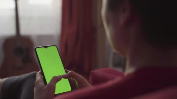 Bakåt syn på Kvinna håller Chroma Key Green Screen Smartphone — Stockvideo