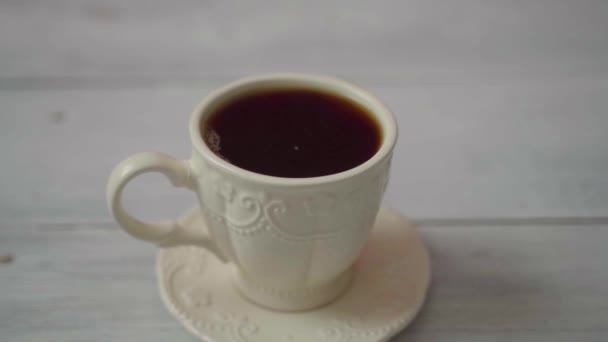 Statisk ram. En kopp med varmt kaffe står på ett vitt träbord — Stockvideo