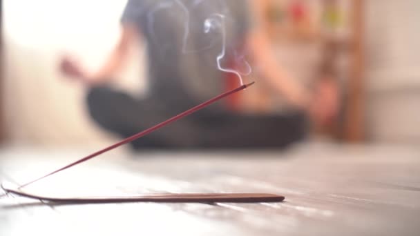 Gőzölgő füstölő bot a padlón, és jógi a háttérben — Stock videók