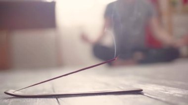 Tütsü tütsüsü yere yakın çekim ve arka planda yoga.