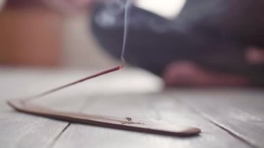 Tütsü tütsüsü yere yakın çekim ve arka planda yoga.
