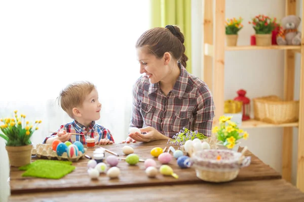 Mother and her son painting Easter eggs. — Stock Photo, Image