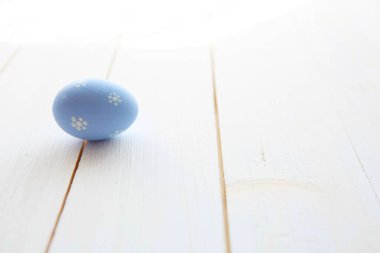 Beyaz ahşap bir masada mavi yumurta. Paskalya tatili geçmişi