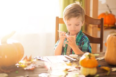 Mutlu Cadılar Bayramı. Çocuklar Cadılar Bayramı 'nı evde kutluyor. Aile şakası mı şeker mi? Evde cadılar bayramı kurabiyeleri için kurabiye hazırlayan sevimli, neşeli çocuk..