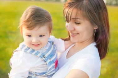 Anne ve sevgili oğlu güneşli arazide kasıtlı güneş parlıyor. Mutlu aile kavramı.