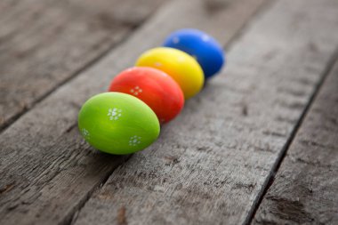 Beyaz ahşap bir yüzeyde birkaç Paskalya yumurtası var. Ahşap masa arkasındaki paskalya yumurtalarının fotokopi alanı
