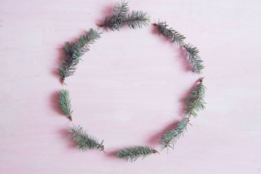 Noel kompozisyonu. Noel çerçevesi, köknar dallarından yapılmış pembe arka planda fotokopi alanı olan. Üst görünüm.