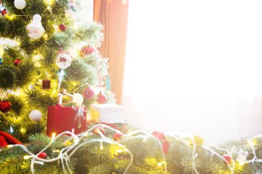 Zarif bir Noel ağacı süslemeleri ve güzel ahşap zeminde hediyeleri var..