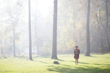 Sonbahar ormanında sabah sisinde güzel bir kadın.