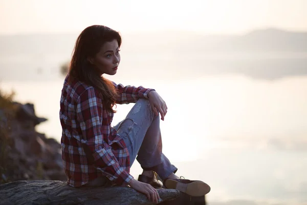 日没前の砂浜や秋の海や湖に座っている女 — ストック写真