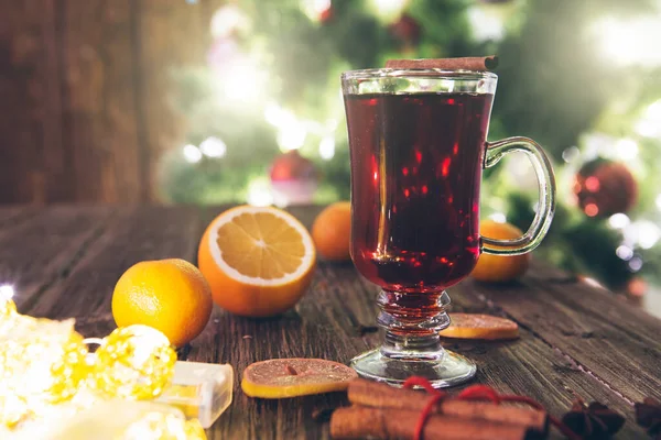 Weihnachtlicher Glühwein Auf Holztisch Über Defokussiertem Christbaumhintergrund Getöntes Bild — Stockfoto