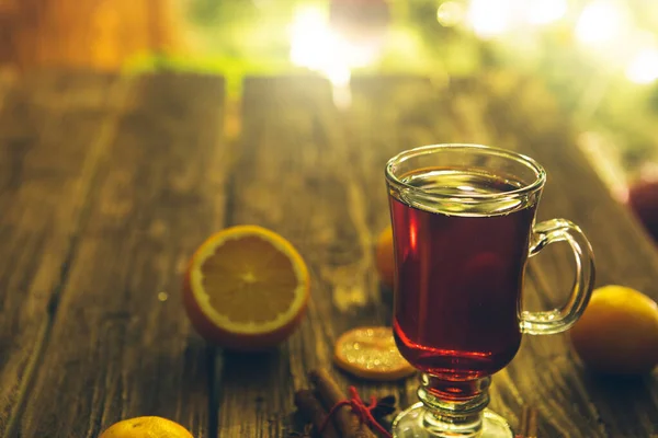 Weihnachtlicher Glühwein Auf Holztisch Über Defokussiertem Christbaumhintergrund Getöntes Bild — Stockfoto