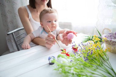 El yapımı Paskalya yumurtaları. Annesinin oğlu olan küçük çocuk Paskalya yumurtalarını boyadı..