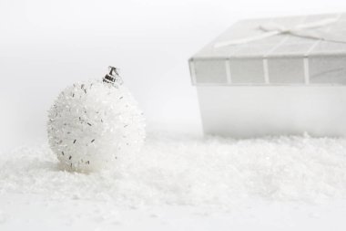 Beyaz arka planda karla süslenmiş Noel hediyeleri