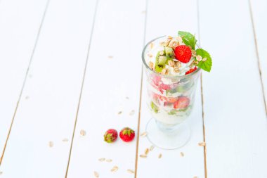 Beyaz ahşap arka planda tatlı yoğurt ve çilek..