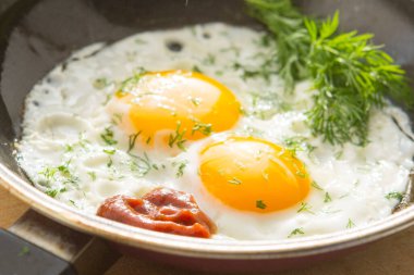 Tavada yumurta ve ahşap masa sapı.