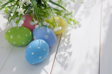 Beyaz ahşap arka planda renkli paskalya yumurtaları. Mutlu Paskalyalar.