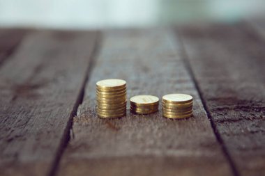 Altın paralar ahşap masaya yığılır. Çapraz İşleme Tonu Renkli.