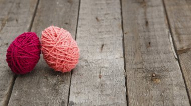 Ahşap masadaki yün iplikten yapılmış renkli paskalya yumurtaları. Mutlu Paskalyalar.