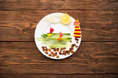 Sağlıklı yaşam için sağlıklı yiyecekler. Sebze gemileri ve deniz feneri ahşap arka planda..