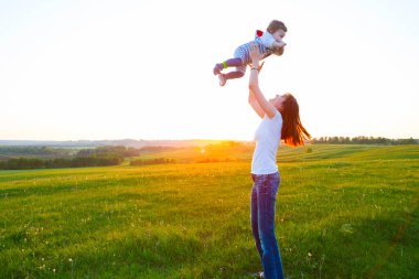 Gün batımında mutlu anne ve oğul. Yaz günbatımında mutlu bir aile. Anne ve bebek..