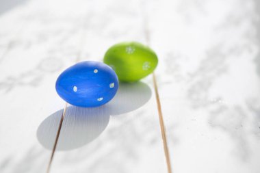 Ahşap arka planda iki mavi ve yeşil Paskalya yumurtası