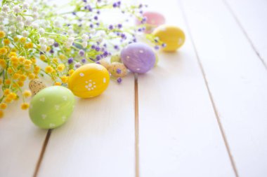 Beyaz ahşap arka planda çiçekli Paskalya yumurtaları