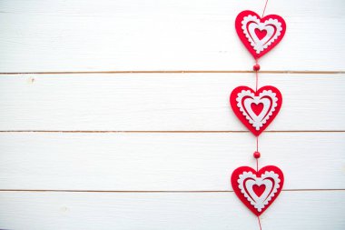 Beyaz boyalı ahşap arka planda asılı kalp çerçevesi