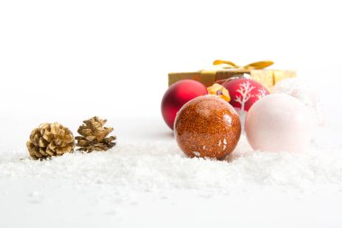 Beyaz arka planda karda üç Noel topu