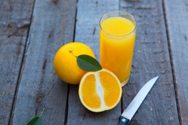 Portakallı portakal suyu, ahşap masanın kenarında bir bıçakla kesilmiş..