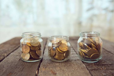 Para dolu cam kavanozlar ahşap masada ruble. Çapraz İşleme Tonu Renkli.