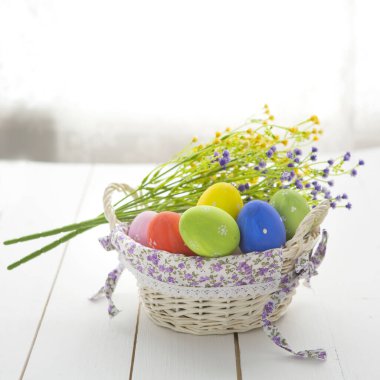 Tahta yüzeyde bir sepette paskalya yumurtaları.
