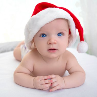 Noel 'de beyaz, yumuşak ekose üzerinde uzanan tatlı erkek bebek.