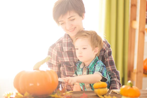 幸せな家族の母親と子供の息子カボチャを彫る ハロウィーンの準備をしている幸せな家族 — ストック写真