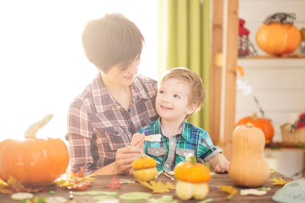 幸せな家族の母親と子供の息子カボチャを彫る ハロウィーンの準備をしている幸せな家族 — ストック写真