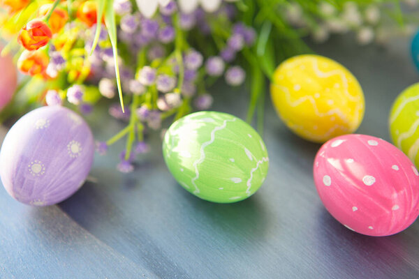 Easter eggs and flowers on a gray wooden planks