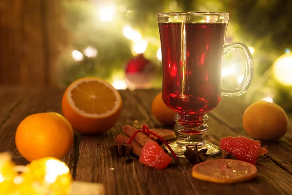 Weihnachtlicher Glühwein Auf Holztisch Über Defokussiertem Christbaumhintergrund Getöntes Bild — Stockfoto