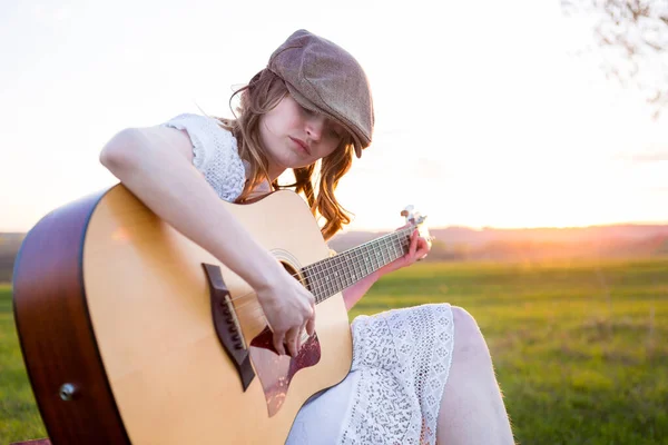 Mädchen Sitzt Mit Akustikgitarre Auf Feld — Stockfoto