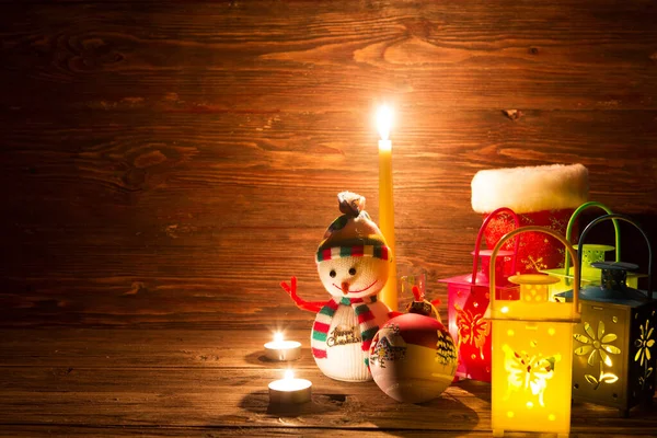 手作りの雪だるま ろうそくと木製のテーブルの背景にクリスマスの装飾が施されたランプ — ストック写真