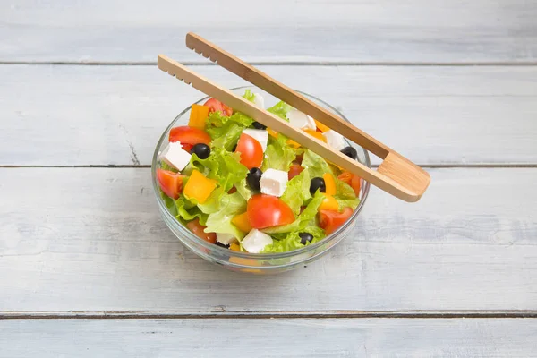 Griekse Salade Glazen Schaal Een Witte Houten Tafelondergrond — Stockfoto