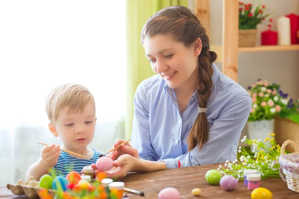Anne ve oğlu Paskalya yumurtası boyuyor. Mutlu aile Paskalya için hazırlanıyor..