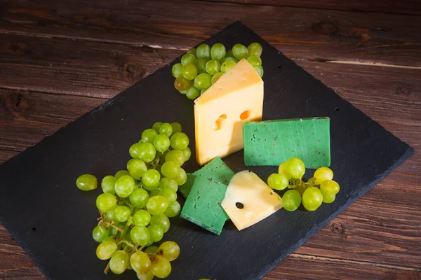 Schot Kaas Groene Druiven Zwart Leien Kaasplankje Houten Tafel — Stockfoto