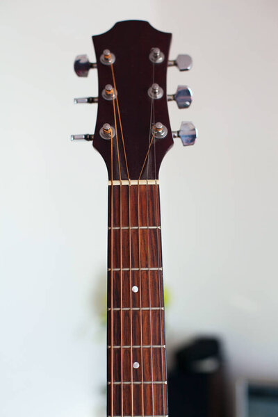 Acoustic guitar fretboard on background