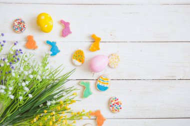 Beyaz ahşap zemin üzerinde renkli paskalya kurabiyeleri