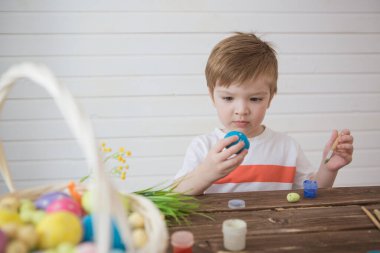Paskalya yumurtalarını boyayan bir çocuk Paskalya 'yı kutlamaya hazırlanıyor.